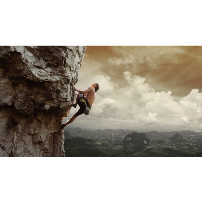 Young man climbing natural rocky wall with tropical valley - ID # 131246312 Young man climbing natural rocky wall with tropical valley - ID # 131246312